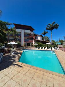a swimming pool in front of a building at Pousada Enseada do Corsário in Guarapari