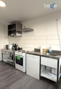 a kitchen with a white stove and a sink at BEGE APARTMENTS WorkSpace in Marl