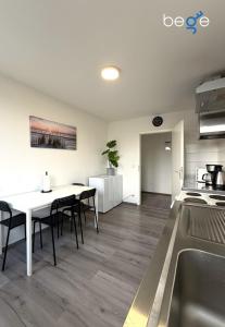 a kitchen and dining room with a table and chairs at BEGE APARTMENTS WorkSpace in Marl