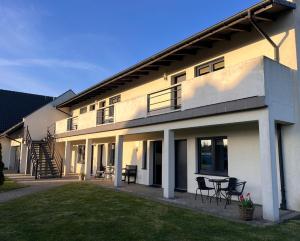 a house with chairs and a table in a yard at Szum Morza in Wrzosowo