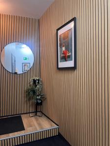 a room with a striped wall with a picture and a plant at Studio Magritte 156 in Boussu