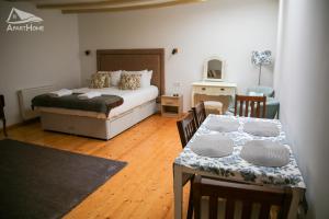 a bedroom with a bed and a table and chairs at ApartHome in Makó