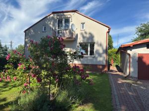 a house with pink flowers in the yard at Serce Jury in Ogrodzieniec