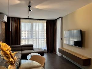 a living room with a couch and a flat screen tv at Apartment Sonata in Varna City
