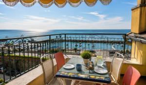 a table and chairs on a balcony with a view of the ocean at Giada Apartments in Moneglia