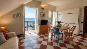 a living room with a table and chairs and a view of the ocean at Giada Apartments in Moneglia
