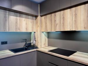 a kitchen with a sink and wooden cabinets at Apartment Sonata in Varna City