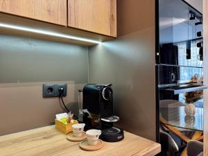 a coffee station with cups on a wooden counter at Apartment Sonata in Varna City +25 photos