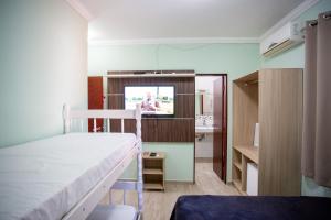 a bedroom with a bed and a tv in a room at POUSADA JURERE in Florianópolis