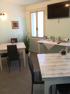 a room with tables and chairs and a tv on the wall at La Casa di Giovanni B&B in Romano D'Ezzelino