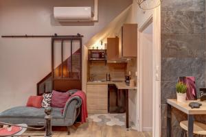 a small room with a bed and a kitchen at Cachette Secrète in Bourgoin