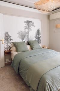 a bedroom with a large bed with palm trees on the wall at Quartier hippodrome in Cagnes-sur-Mer