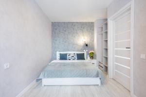 a white bedroom with a bed and a book shelf at Fayna Town Comfort #173 in Kyiv