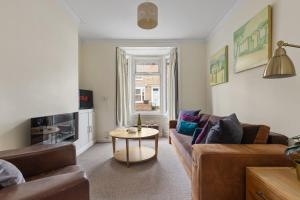 a living room with a couch and a table at Park Crescent - Quaint Victorian Home With Free Parking in York