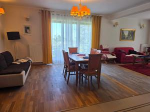 a living room with a table and chairs and a couch at Dom na Wynajem Gdynia Grabówek in Gdynia
