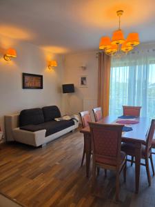 a living room with a dining room table and a couch at Dom na Wynajem Gdynia Grabówek in Gdynia