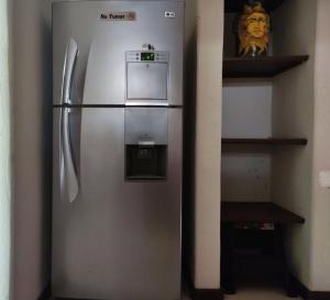 a stainless steel refrigerator in a corner of a room at Top Pool Condo in Ixtapa's Hotel Area in Ixtapa