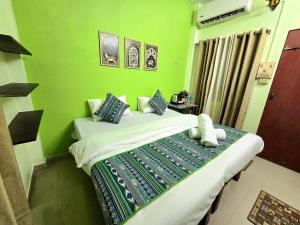 a green bedroom with a bed in a room at Zipcode Kashi in Varanasi