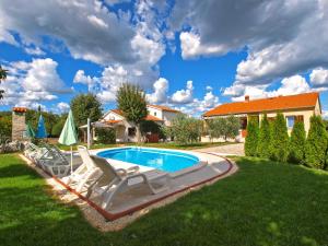 a swimming pool in a yard with two lounge chairs at House Pavicini 333 in Pavicini