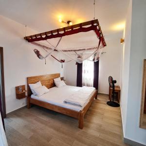 a bedroom with a bed with a canopy in it at Villa Céllia in Tsivonoakely +73 photos