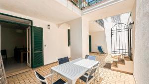 a patio with a table and chairs and a door at Acquafredda Ritrovata in Acquafredda