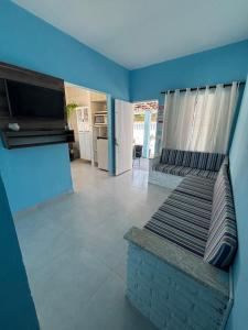 a living room with a couch and a tv at -TROPICAL SUÍTES- ao lado do SESC-BERTIOGA in Bertioga