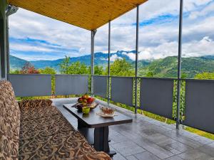 a balcony with a table and a view of mountains at panorama lasuriashi in Lasuriashi