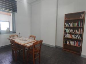 a dining room with a table and a book shelf at Sisters home in Marcinelle