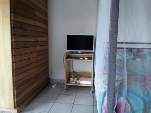 a bedroom with a bed and a television on a table at La Case du Pêcheur in La Trinité