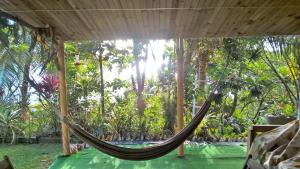 a hammock in a room with trees at La Case du Pêcheur in La Trinité