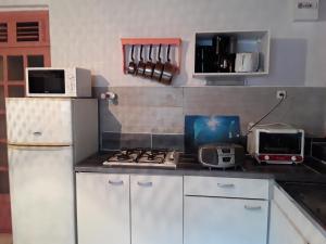 a kitchen with a white refrigerator and a stove at La Case du Pêcheur in La Trinité