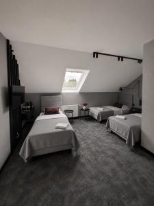 a room with two beds and a window at Willa Czarny Puzzel in Tarnowska Wola