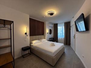 a bedroom with a bed and a flat screen tv at Lumen - Bright Stay in Bucharest in Bucharest