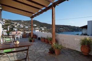 a patio with tables and potted plants on a building at Marietta Studios Patmos in Skala