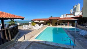 a swimming pool with a view of the ocean at Ponta Negra Palace in Natal