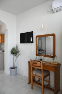 a desk with a mirror and a chair in a room at Venus Studios in Vlachata