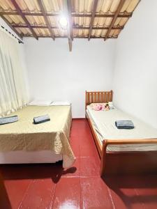 two beds sitting next to each other in a room at Sítio Sombra da Figueira in Paty do Alferes