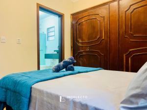 a teddy bear sitting on a bed in a bedroom at Casa Central Px Matriz c/ Churrasqueira, 2 Suítes in Poços de Caldas
