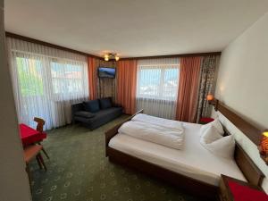 a hotel room with a bed and a couch at Haus Alpenblick in Serfaus +6 photos