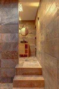 a hallway with a stone wall with stairs and a table at Cachette Secrète in Bourgoin