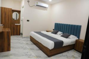a bedroom with a bed with a blue headboard at Hotel Velvet Vista in Rishīkesh