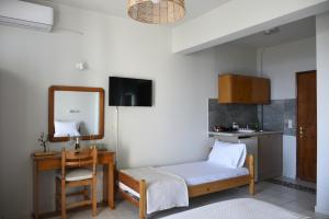 a room with a bed and a mirror and a table at Venus Studios in Vlachata