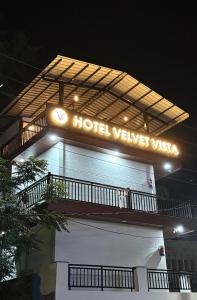 a hotel sign on top of a building at night at Hotel Velvet Vista in Rishīkesh
