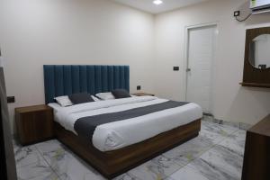 a bedroom with a large bed with a blue headboard at Hotel Velvet Vista in Rishīkesh