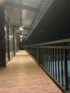 a boardwalk leading to the water at night at Hotel Velvet Vista in Rishīkesh +2 photos