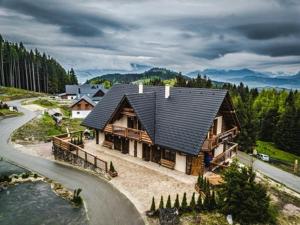 a house with a black roof on the side of a road at Chalupa Katka in Dolný Kubín
