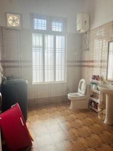 a bathroom with a toilet and a sink and a red suitcase at White View Park in Dharmsāla +18 photos