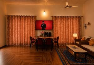 a living room with a table and a tv at White View Park in Dharmsāla