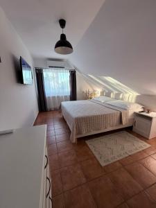 a bedroom with a bed and a tv on a wall at Munkácsy Apartmanok in Balatonfenyves