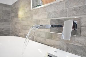 a bath tub with water coming out of a faucet at 1 Bed in Gainsborough oc-66230 in Heapham +17 photos